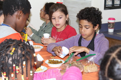 children at table doing craftwork for volunteer project