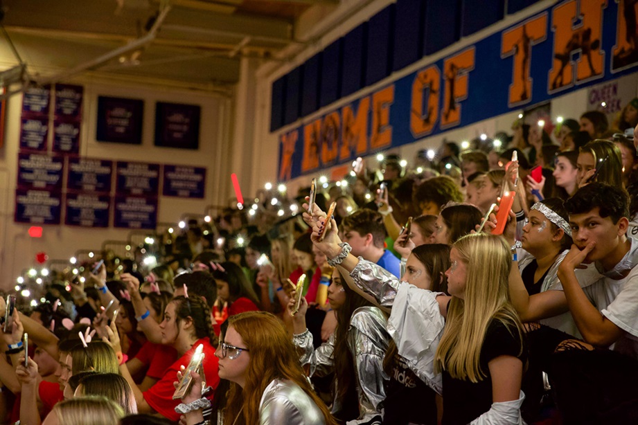 Large student event Digital4Good teens raise phone flashlights