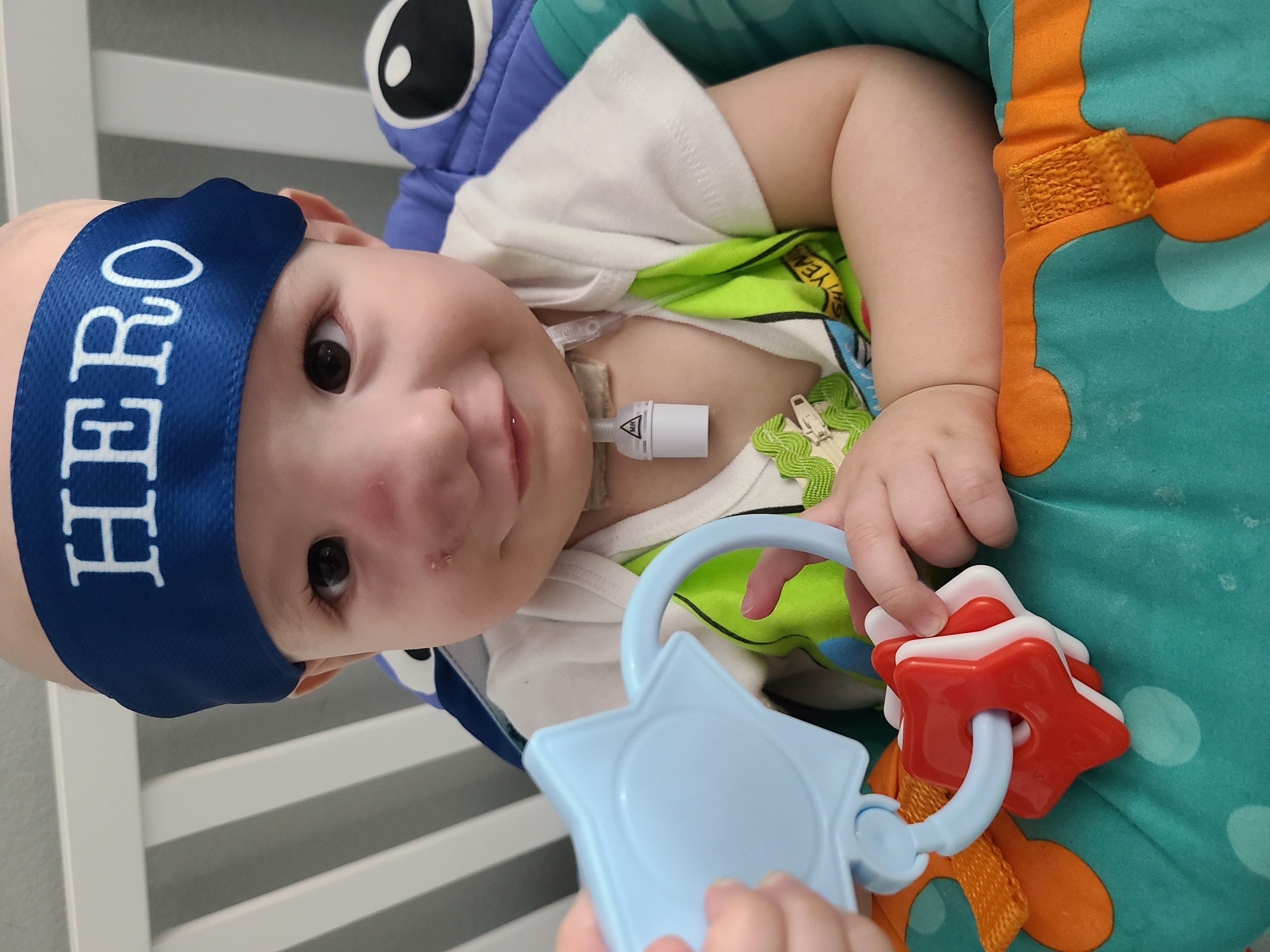 child with cancer in hospital bed plays with toy, The National Children's Cancer Society