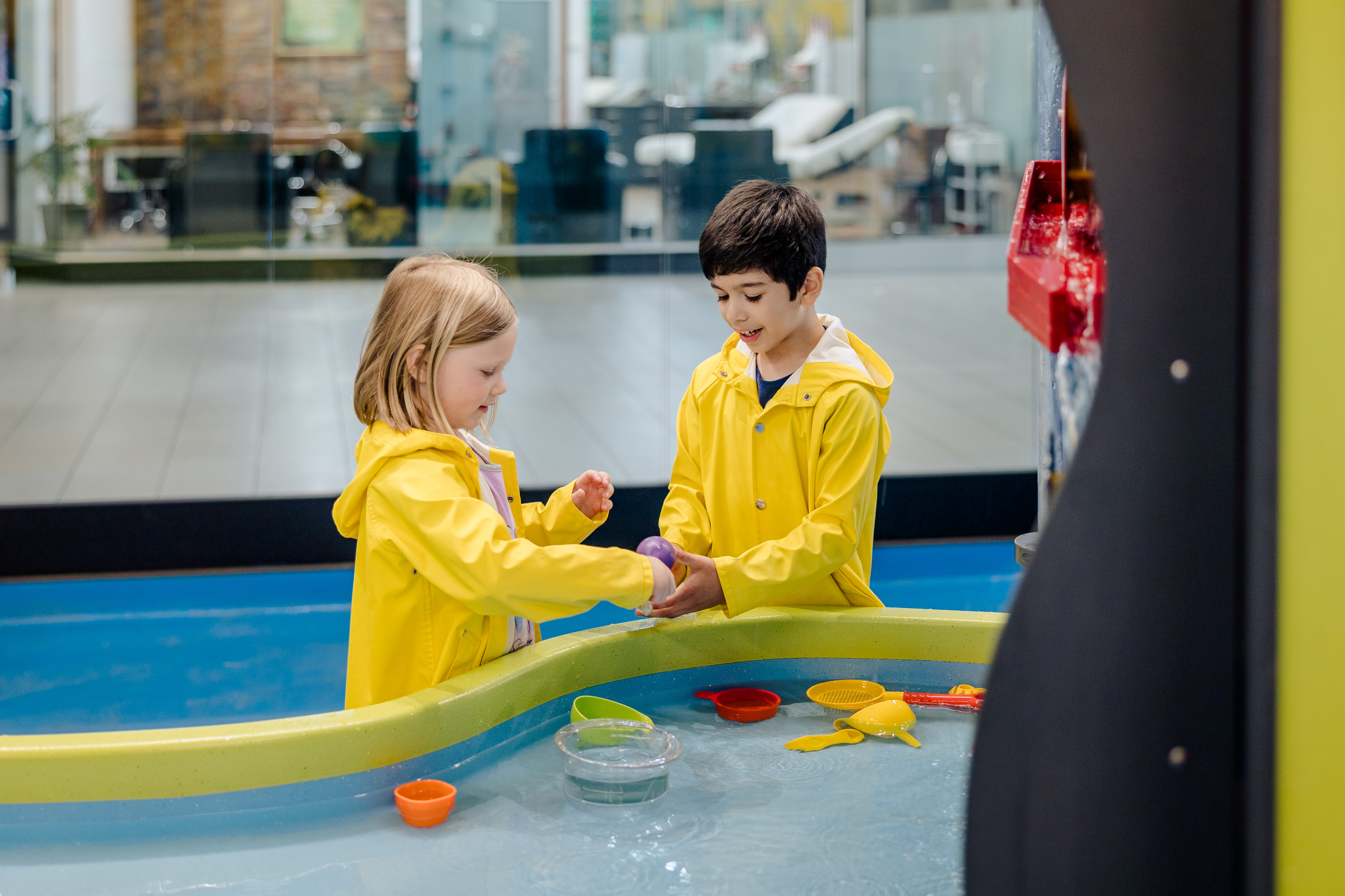 boy, girl, yellow slickers, water play, SPARK