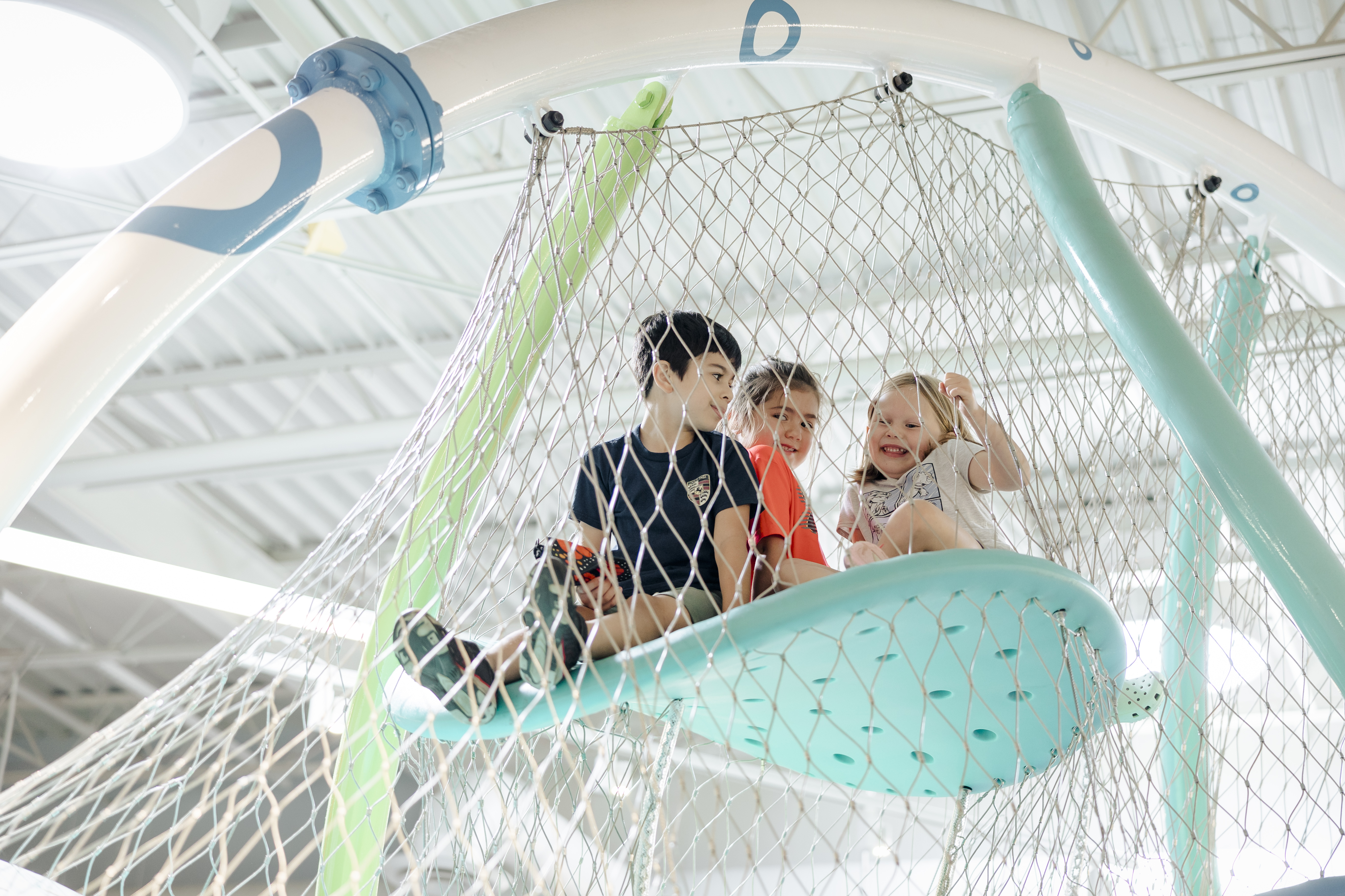 Children swing in a net at SPARK