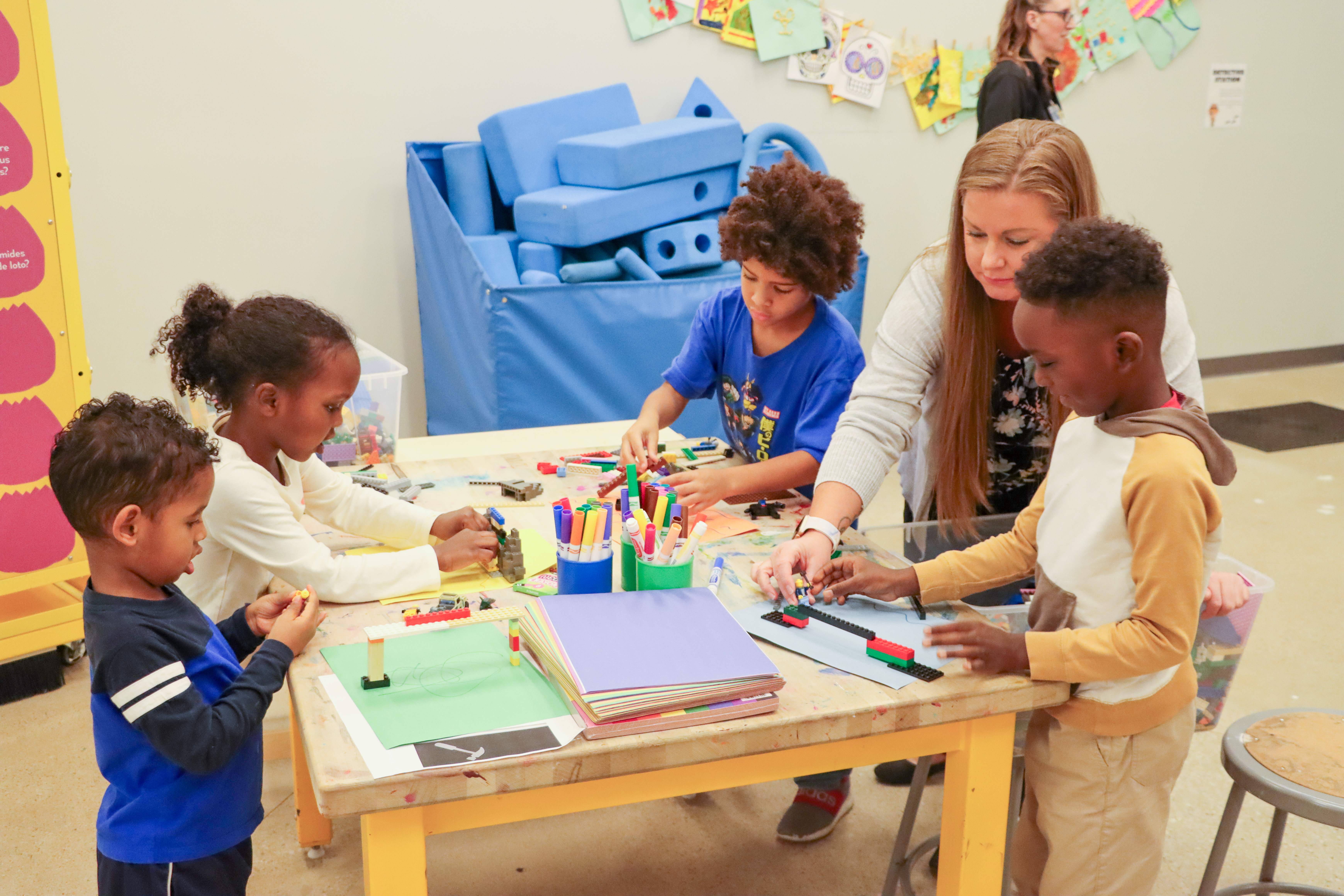 Young boys, woman, draw and play at SPARK