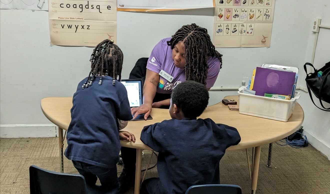 Joyful Readers students work with tutor and computer